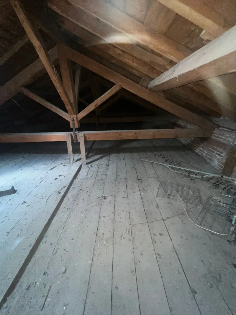 Buhardilla con estructura de madera y suelo de tablas sin ningún aislamiento