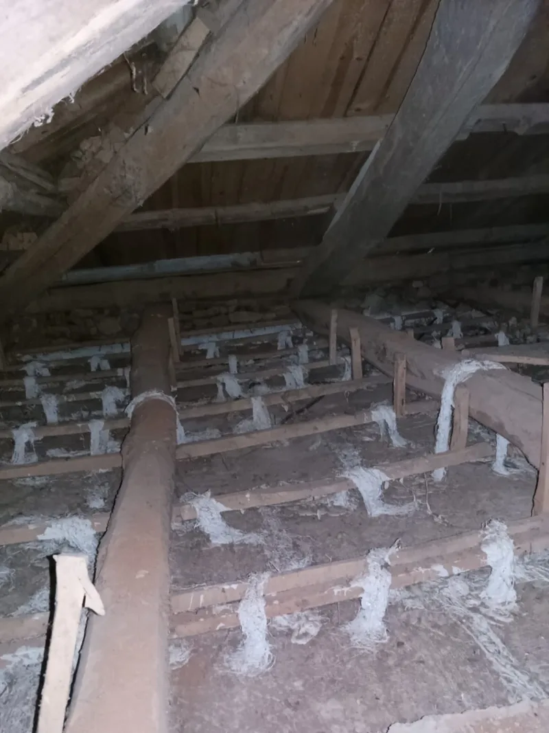 Desván de vivienda antigua con aislamiento degradado entre las viguetas